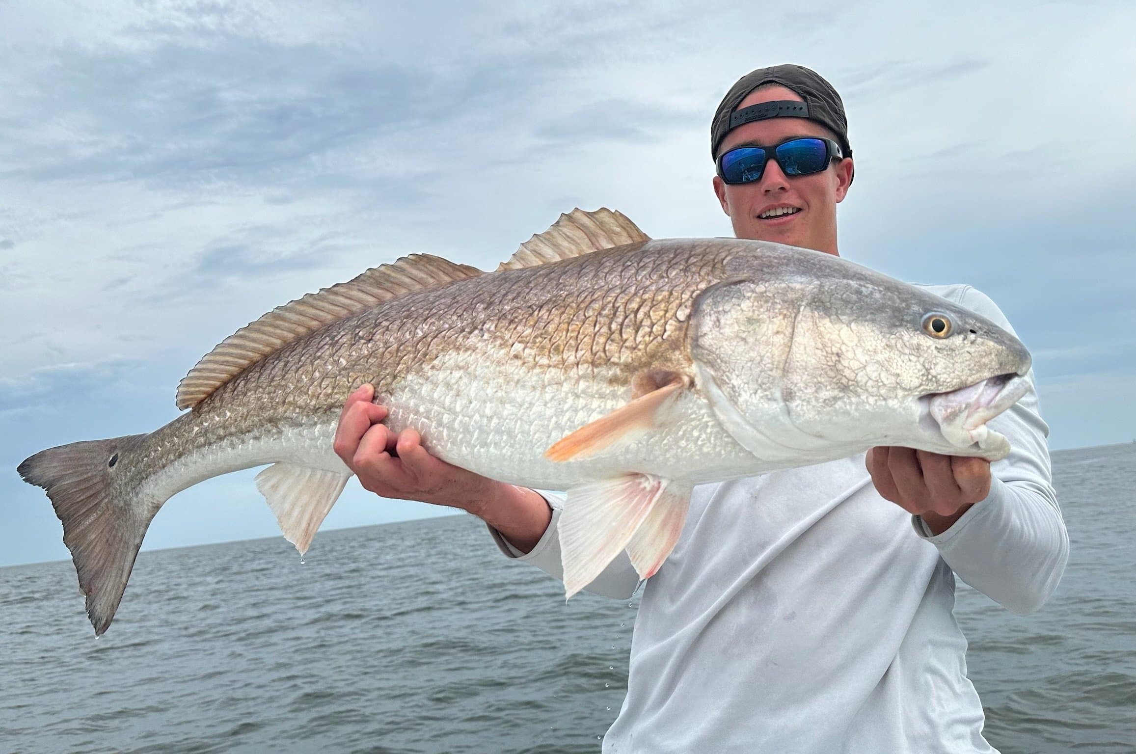 Captain Joseph Christy holding a redfish